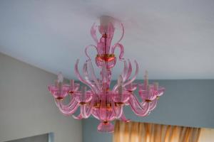 una lámpara de araña de cristal rosa colgando del techo en Loft Apartments en Komotini