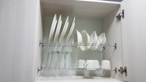 a shelf with white plates and vases on it at ELEGANTE, CÓMODO Y MODERNO APARTAMENTO - SUR DE CALI in Cali +50 photos