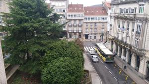 a city street with a bus and cars and buildings at Pensión Mar Azul in Santiago de Compostela