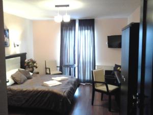 セイニにあるHotel Skarpaのベッド、デスク、椅子が備わるホテルルームです。