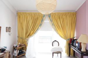 a room with a large window with yellow curtains at Sea Side Villa Alexandra in Alissos