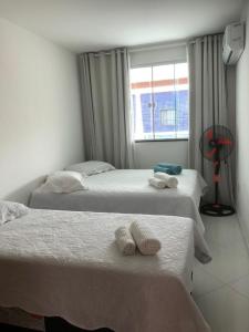 1 dormitorio con 2 camas y toallas. en Hospedagem Central II, en Arraial do Cabo