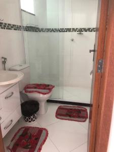 y baño con ducha, aseo y lavamanos. en Hospedagem Central II, en Arraial do Cabo