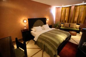a bedroom with a large bed and a couch at Riad Dar Haven in Tamraght Ou Fella
