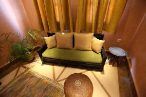 a green couch in front of a window at Riad Dar Haven in Tamraght Ou Fella