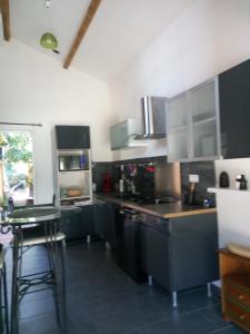 une cuisine avec des armoires noires et un comptoir dans l'établissement Gite chez mamiyo gallargues le montueux, à Gallargues-le-Montueux