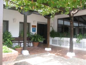 ein Gebäude mit Bäumen und Pflanzen davor in der Unterkunft Hotel El Puerto in Puerto Lápice