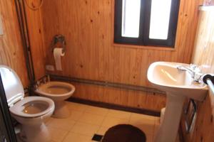 ein Holzbadezimmer mit einem WC und einem Waschbecken in der Unterkunft La Casa de Tafí del Valle in Tafí del Valle
