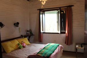 ein Schlafzimmer mit einem Bett mit zwei Stofftieren darauf in der Unterkunft La Casa de Tafí del Valle in Tafí del Valle