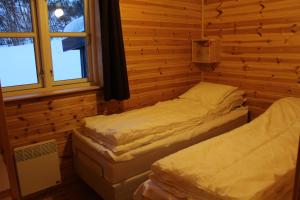 a room with two beds in a log cabin at Linnaeus - 6 person cabin in Al