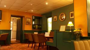a living room filled with furniture and a clock on the wall at The Waverley Hotel Whitehaven in Whitehaven