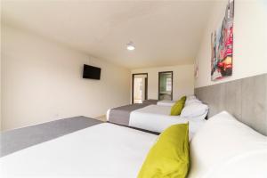 a bedroom with two beds and a flat screen tv at Ayenda 1055 Agora INN Corferias in Bogotá