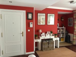 um quarto com paredes vermelhas e uma porta branca em albobide em Bakio
