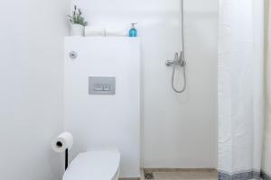 y baño blanco con aseo y ducha. en Renovated Typical Baixa Apartment, By TimeCooler, en Lisboa