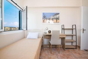 um quarto com uma secretária e uma janela em City walls sea view em Corfu Town