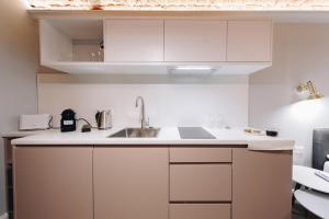 kuchnia z białymi szafkami i zlewem w obiekcie Platan Apartments-5 min Main sqr-large bed-unique w Krakowie