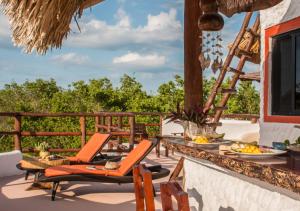 a patio with chairs and a table with food on it at Villa Los Mangles Boutique Hotel in Holbox Island