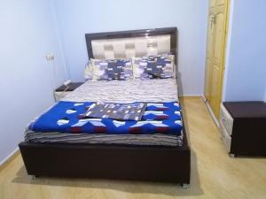 Bett in einem Schlafzimmer mit blauer Wand in der Unterkunft Best Room in Fès