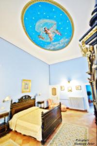 1 dormitorio con 1 cama y una pintura en el techo en B&B Casa Cavalli, en Lucera
