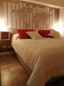 star apartment olivos في أوليفوس: غرفة نوم بسرير كبير ومخدات حمراء وبيضاء
