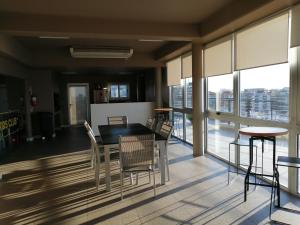 a dining room with a table and chairs and windows at star apartment olivos in Olivos