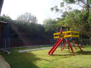 a playground with a slide on the grass at Chacara Dois Lagos - Mairinque in Mairinque