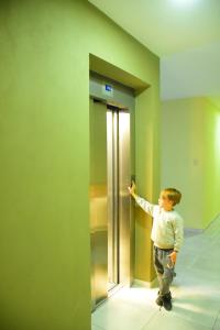 a young boy standing in front of an elevator at HOTEL MIRAMAR in Miramar