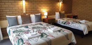 Habitación de hotel con 2 camas y toallas. en Sandpipers @ Millicent, en Millicent