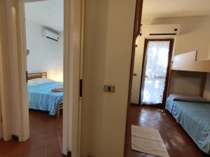 um quarto com duas camas e uma porta para um quarto em Villino Ondine em Santa Margherita di Pula