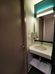 y baño con lavabo y espejo. en ibis budget Itagui en Medellín