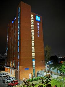 un edificio de hotel con un cartel en él por la noche en ibis budget Itagui en Medellín