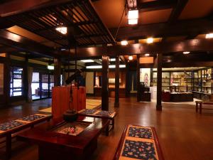 a large room with tables and rugs in a building at Matsunoi in Takayama