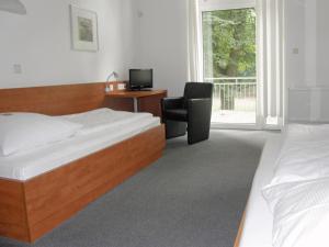 ボンにあるCJD Bonn Castellのベッドルーム1室(ベッド2台、デスク、椅子付)
