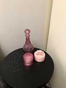 a black table with a bottle and a pink cake at The Old Coolstore - Jonathon Apartment in Merricks North