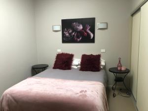 a bedroom with a bed with purple pillows on it at The Old Coolstore - Jonathon Apartment in Merricks North