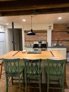 a kitchen with a large wooden table with green chairs at Innkeeper's Place B&B in Stafford Springs