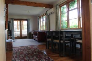 a dining room with a table and chairs and windows at Batch with a View in Te Anau