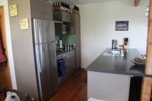 a kitchen with a stainless steel refrigerator at Batch with a View in Te Anau