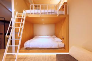 a bedroom with two bunk beds and a ladder at Chikura Tsunagu Hotel in Minamiboso