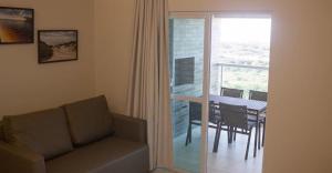 sala de estar con sofá, mesa y balcón en Salinas Park Resort, en Salinópolis