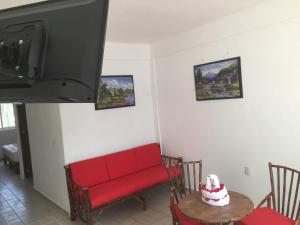 a living room with a red couch and a table at DEPARTAMENTOS LALO in Zihuatanejo