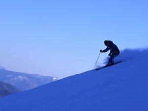 a person is skiing down a snow covered slope at BEYOND HOTEL Takayama 2nd in Takayama
