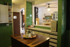 cocina con paredes verdes y mesa de madera en Casa Areka, en Panamá