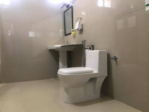 a bathroom with a white toilet and a sink at Deogarh Hills A Village Experience Property in Kaunthal +122 photos