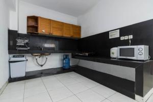 a small kitchen with a microwave and a sink at RedDoorz Plus @ Pasar Baru in Jakarta