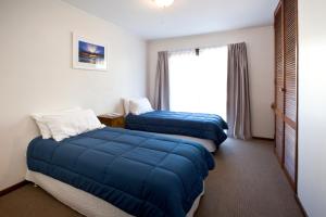 
a bed room with two beds and a window at North Star Holiday Resort in Hastings Point
