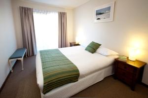 
a bedroom with a bed and a lamp at North Star Holiday Resort in Hastings Point
