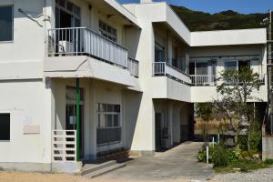 an apartment building with balconies and a driveway at Uminoyado Yamawo in Tonosho