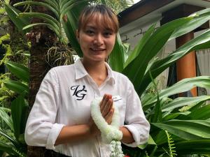 a woman is standing in front of a plant at Villa on The Rocks, 4 bedrooms, Phuket in Surin Beach