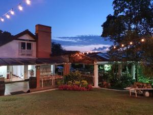 une maison avec une terrasse éclairée la nuit dans l'établissement Hotel Casa Madero, à Envigado